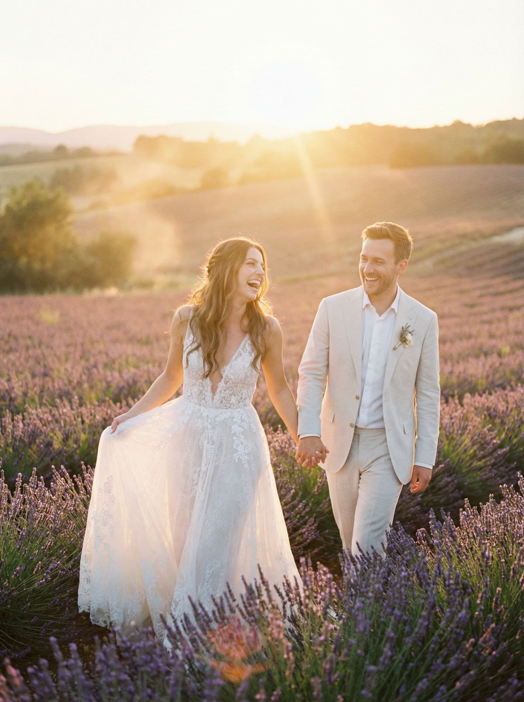 Couple walking through a lavender field at sunset